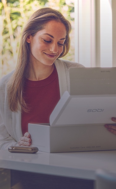 امرأة تفتح علبة منتج IQOS.